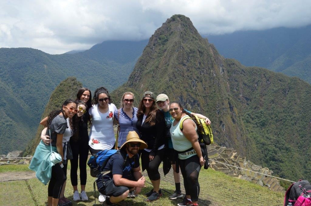 Cusco volunteers in front of machu pichu amazing scenery