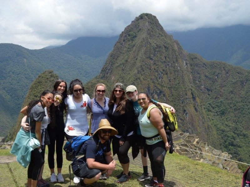 Cusco volunteers in front of machu pichu amazing scenery