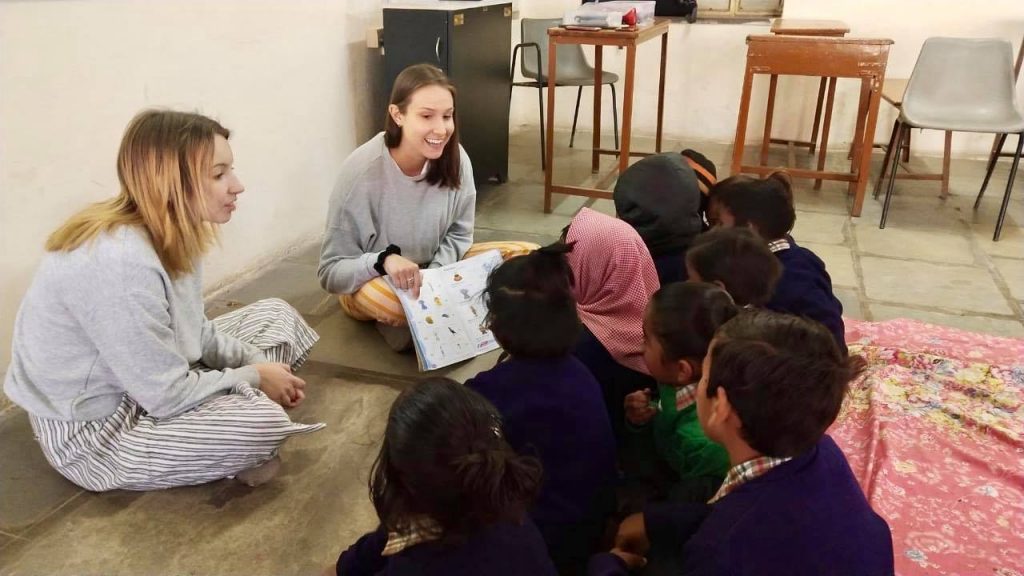 volunteers reading books to children in nepal
