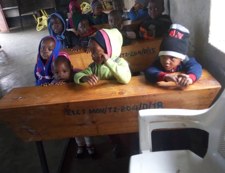 Tanzanian children sitting on school desks