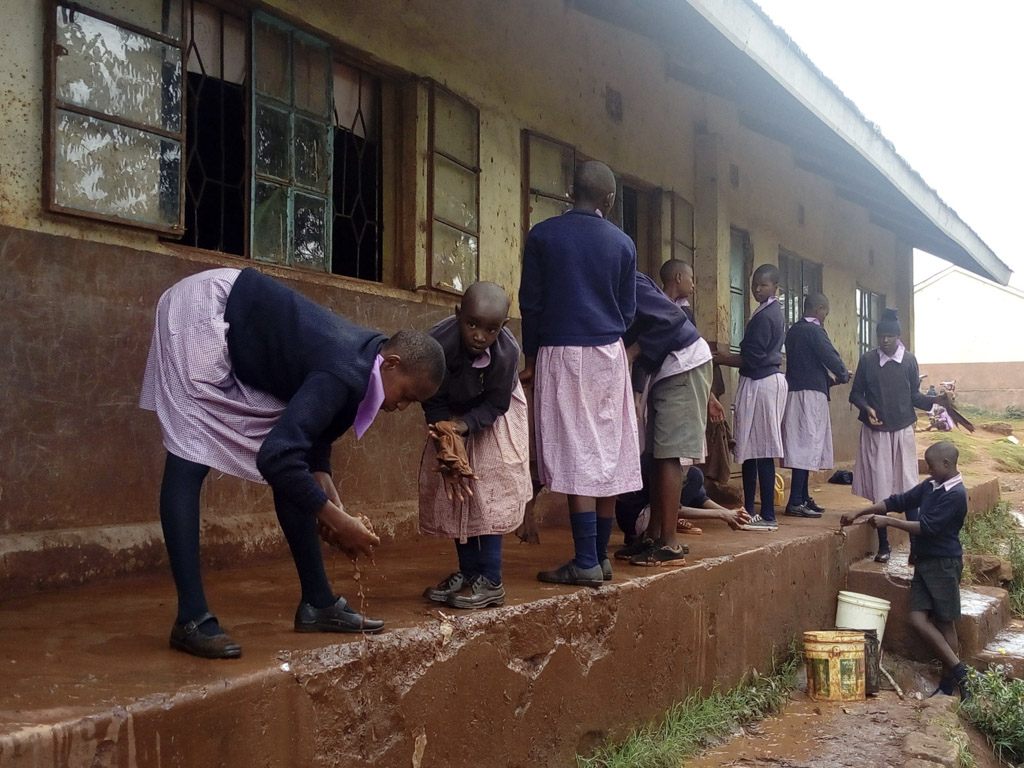 Kenyan children cleaning outside thier classroom-2