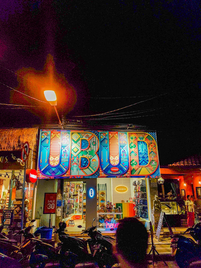 'Ubud' shop sign in street at night