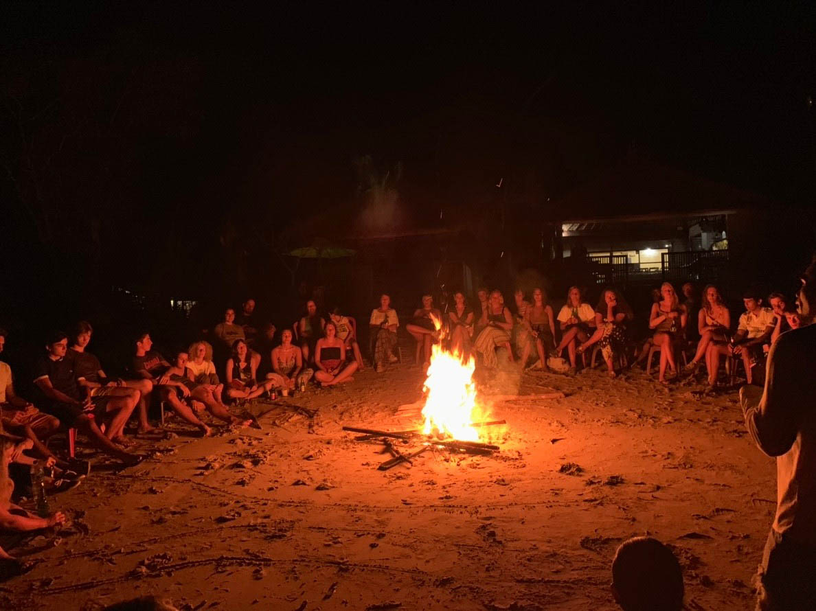big group sitting around a bonfire