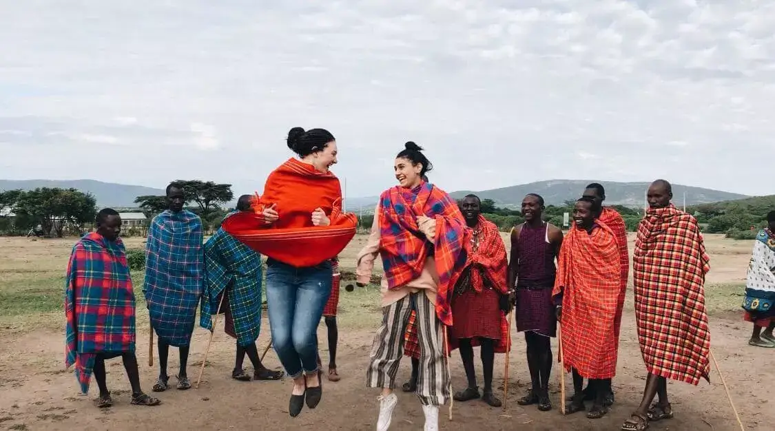 girls jumping with group of Maasai men