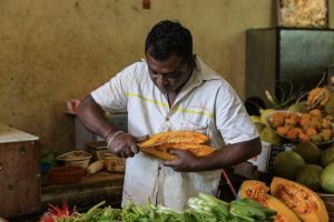 man cutting fruit