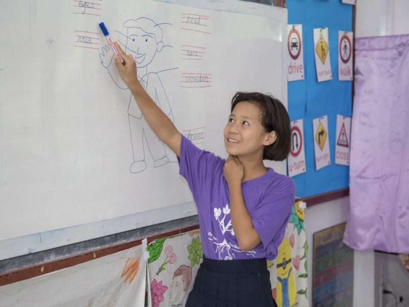 Student filling out activity on white board
