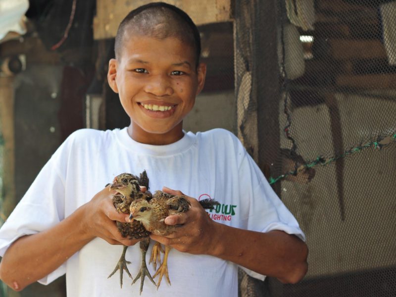 boy from shelter holding chicks-