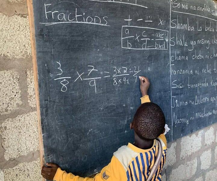 child writing on blackboard