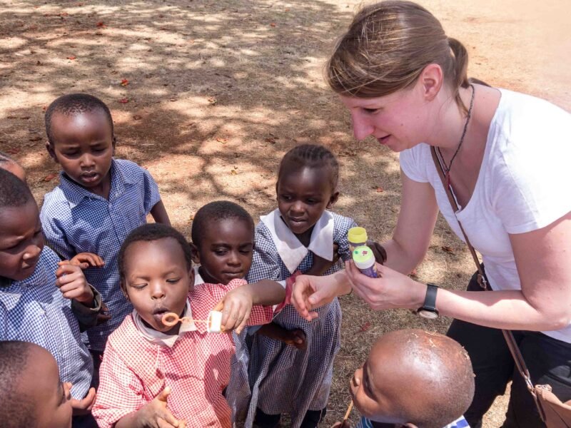 Participant and students blowing bubbles