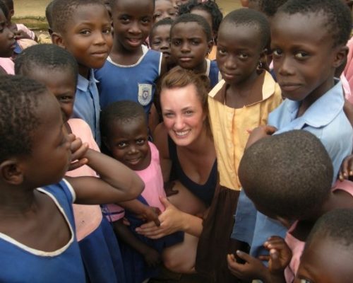 volunteer surrounded by children in Ghana