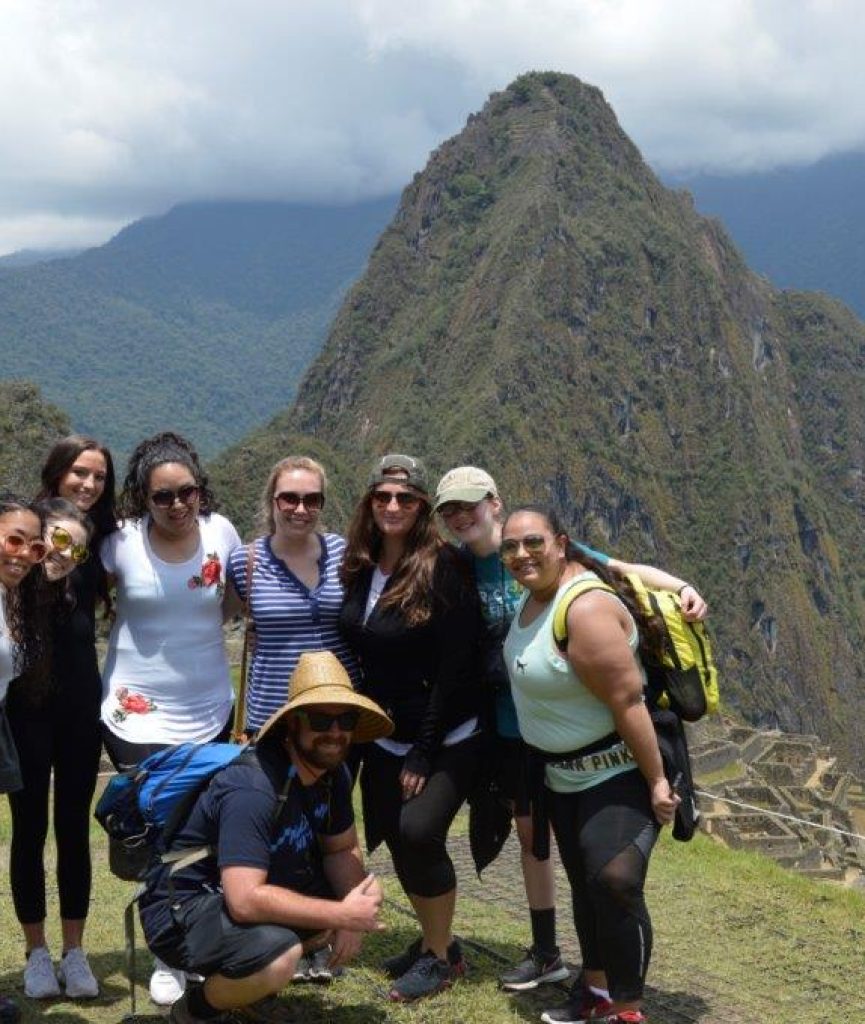 Cusco volunteers in front of machu pichu amazing scenery